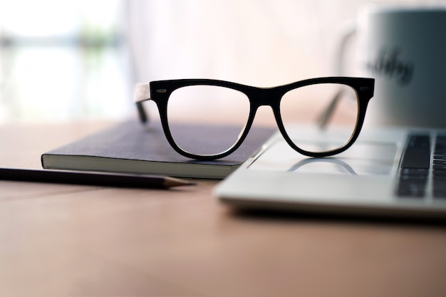 Writer's career on the desk with white coffee mugs, notebooks, pencils, glasses