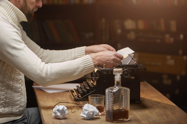 The writers hands correcting a sheet of paper in an old typewriter