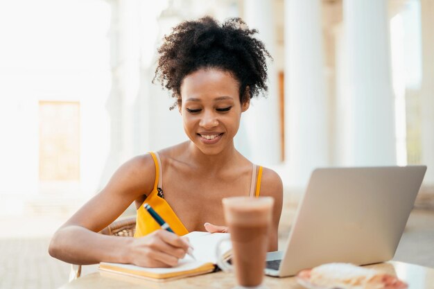 Writes a message to the mail on the laptop during the lunch break Young woman Brazilian