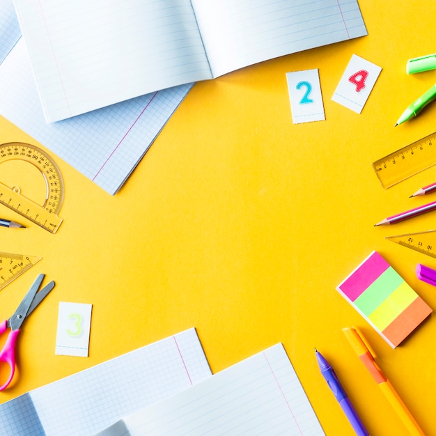 Writing-books, pens, pencils, numbers and rulers on a yellow background