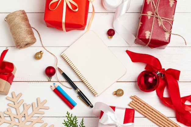 Writing christmas greeting cards. Open notepad with pen on decorated wooden table