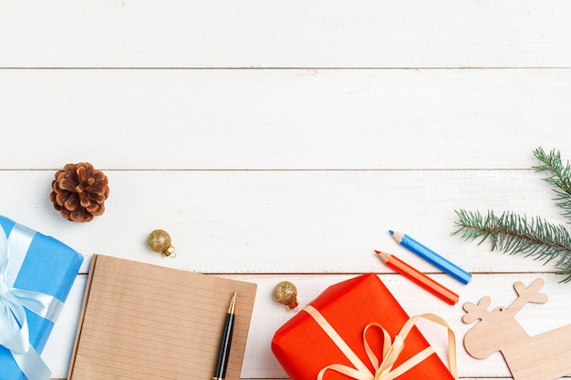 Writing christmas greeting cards. Open notepad with pen on decorated wooden table