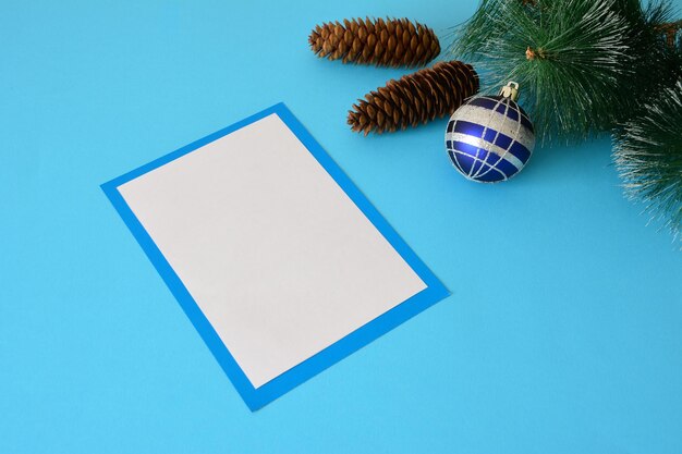 writing christmas letter, pine branches and cones on blue background