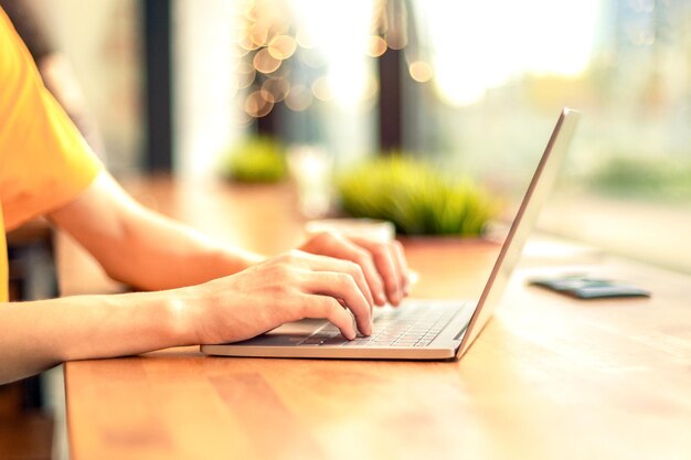 Writing hands of a young man working on laptop