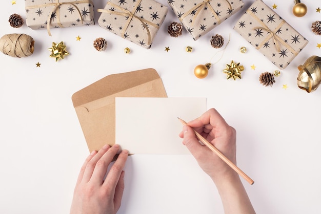 Writing letter to Santa Claus concept. Top above overhead close up first person view photo of female hands holding pen and blank page