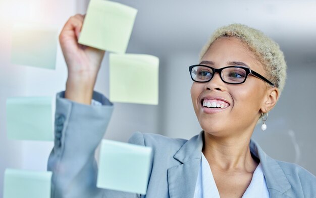 Writing planning and happy business woman in office with sticky note goal idea or strategy schedule smile and happy female manager brainstorming calendar mission or agenda management or growth