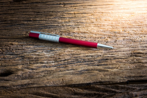 Writing red pen on the wooden background. vintage tone