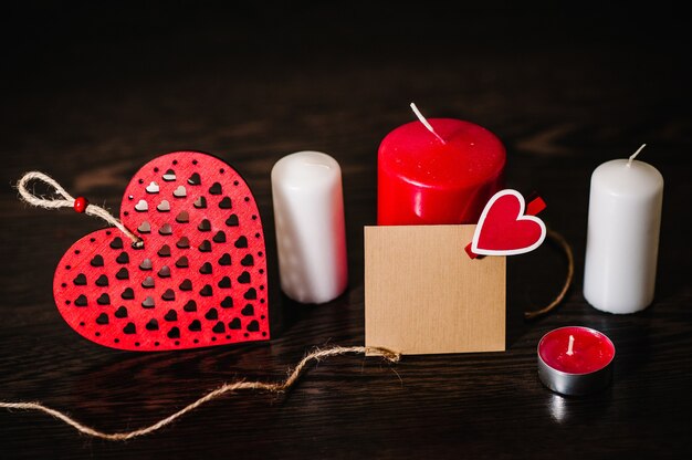 Writing romantic letters on empty paper sheet, note for text message. Love concept with candle. Empty greeting card with red hearts