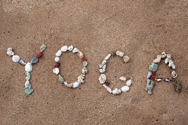 Writing with shells text Yoga on beach