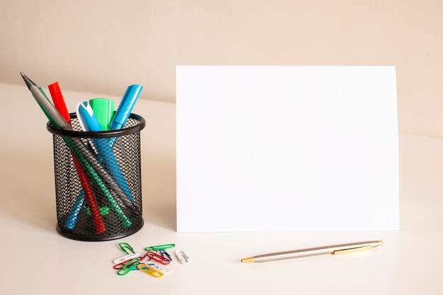 Written on a white folded sheet of paper on the table. Nearby are pens and pencils. Business concept.