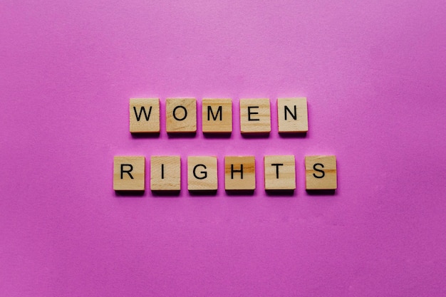 사진 분홍색 배경에 스크래블 문자로 영어로 여성의 권리를 작성했습니다.
