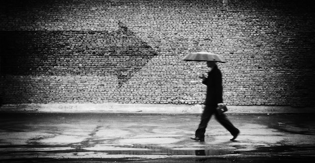 Photo wrong way. a man with umbrella. conceptual image, film grain added