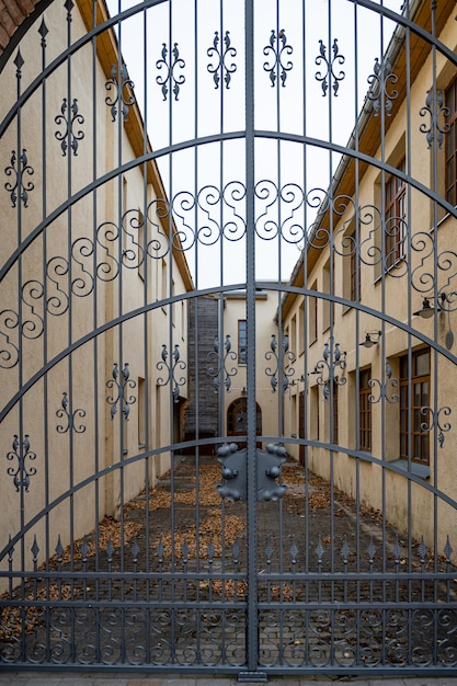 Wrought iron gate with a blurred view of a small courtyard in the background