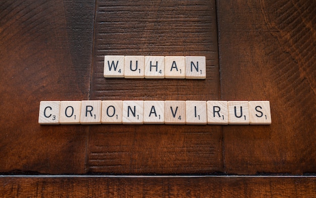 Wuhan coronavirus made out of wooden tiles on a wooden table: health and medical concept