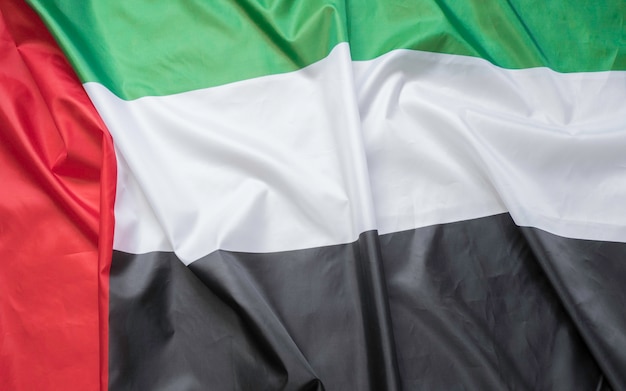 Wuivende stoffentextuur van de vlag met de kleur van de verenigde arabische emiraten, de echte textuurvlag van de vae