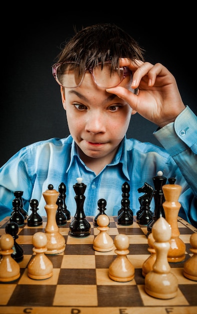 Photo wunderkind play chess. funny nerd boy.