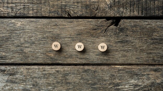 Фото Знак www написан на трех деревянных кругах, помещенных на деревенские деревянные доски.