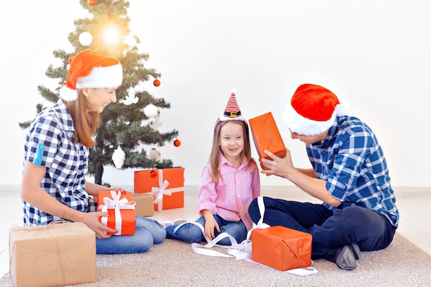 X-mas en vakantie concept - familie opening kerstcadeau voor boom.