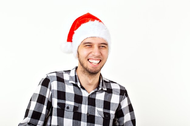 X-mas, winter holidays and people concept - funny emotional man in santa claus hat over white