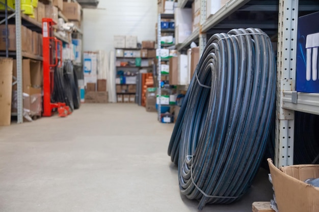 X9Pvc pipes wound in coils on shelves of store's warehouse