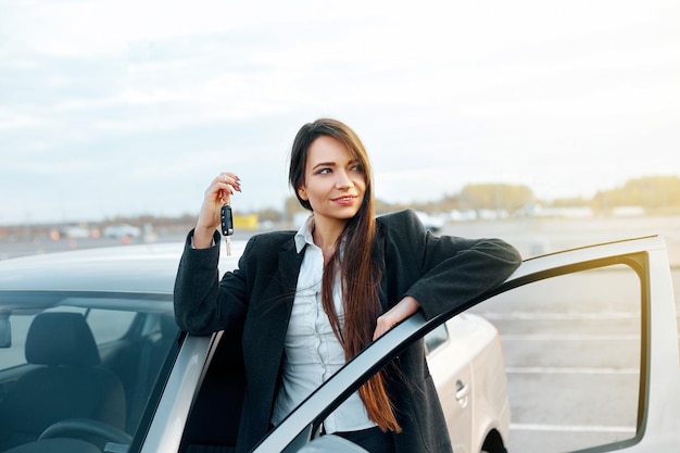 XACar-chauffeursvrouw die lacht met nieuwe autosleutels