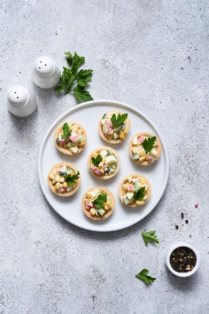 XASalad with crab meat and corn in tartlets on a concrete background