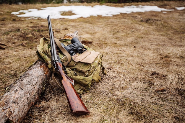 Foto xaset di attrezzatura da caccia militare con fucile nella foresta durante la stagione di caccia caccia bushcraft e concetto di pistola