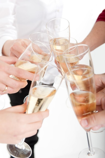 XASeven hands raising champagne flutes on a toastxA