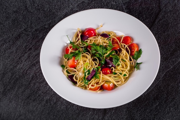 XASpaghetti puttanesca spaghetti with black olives and cherry tomatoes