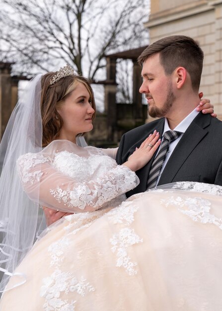 XAThe groom gently holds the young bride in his arms Closeup Love