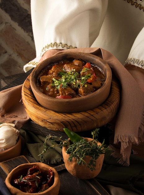 XAVertical shot of a waitress presenting a meat stew