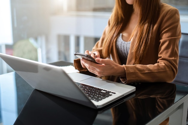 現代のオフィスでのXAWorkingプロセス若い女性のアカウントマネージャーが新しいビジネスプロジェクトでテーブルで作業している現代的なラップトップを使用してキーボードを入力するHorizontalxAxA
