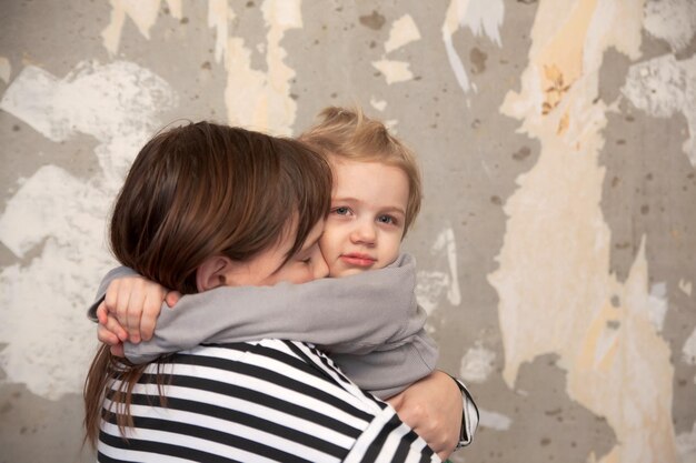 Xdxatwo little children standing in embrace at destroyed wall\
and afraid concept of latest news in world about russia\'s attack on\
ukrainexdxa