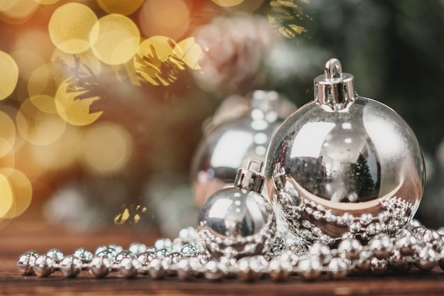Xmas baubles on wooden table on bokeh background