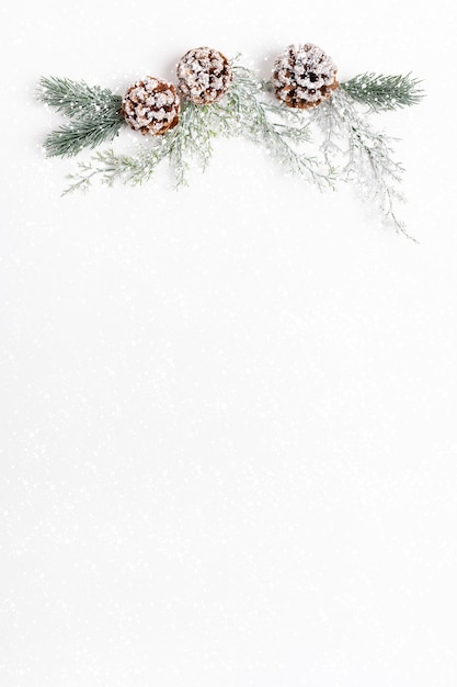 Xmas feestelijke kerstversiering gemaakt van takken en dennenappels op de top van een leeg wit vel met sneeuw