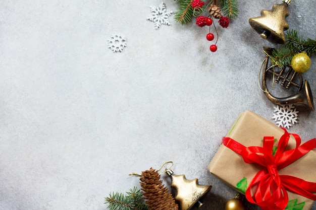 Xmas gift box, branch of a Christmas tree and decorations on a gray stone