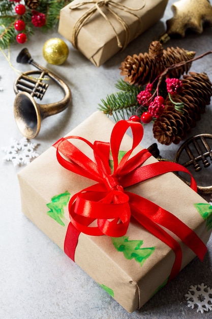 Xmas gift box, branch of a Christmas tree and decorations on a gray stone