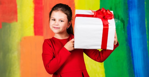 Foto acquisto di regali di natale tradizione di famiglia bellissimo pacchetto regalo regala buon natale e buone vacanze vacanze invernali confezione regalo per bambina stretta confezione regalo per bambini sfondo colorato