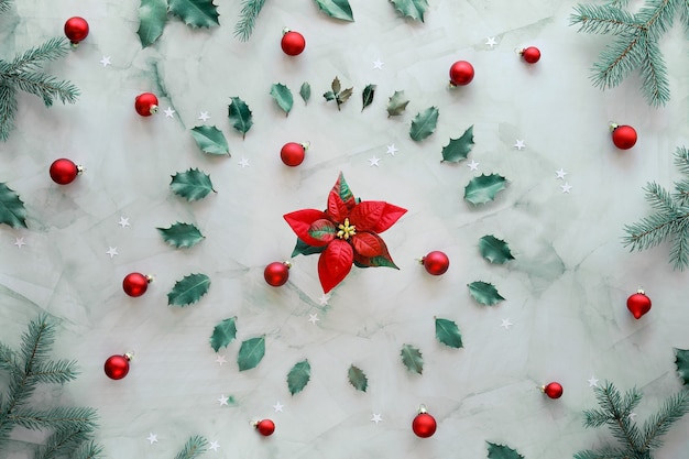 Xmas met groene natuurlijke spartakjes, hulstblaadjes en rode glazen kerstballen.