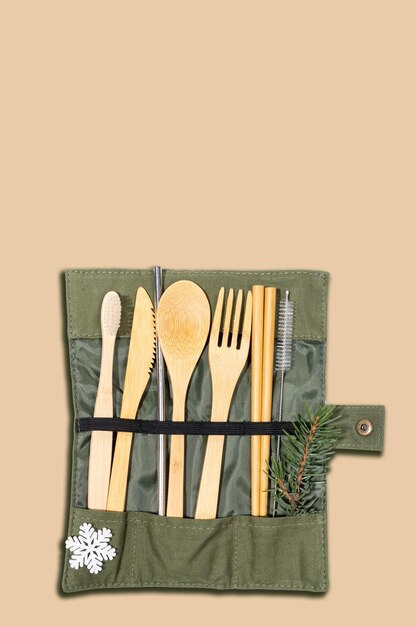 Photo xmas set of eco friendly cutlery and hygiene products in textile case snowflake fir twig on beige