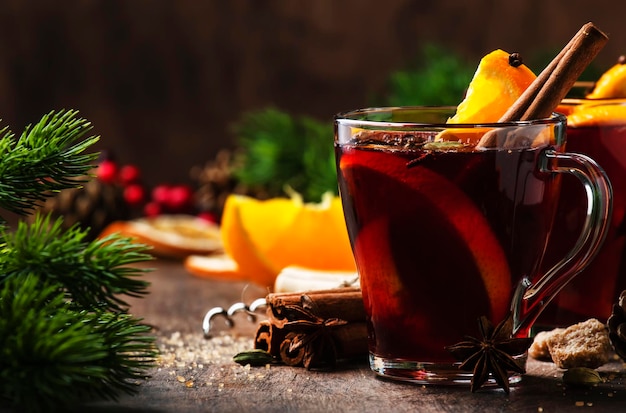 Xmas warme glühwein met kruiden en sinaasappel op houten rustieke tafel Traditionele kerst- of nieuwjaarsverwarmende drank in feestelijke tafelsetting