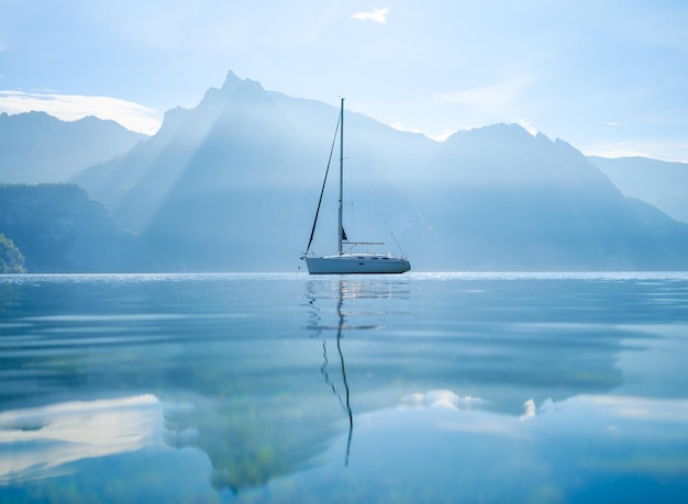 A yacht against the backdrop of the mountains in Switzerland Calm water and bright sunny day A popular place to travel and relax xA
