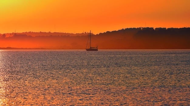 Yacht on a blue sea with golden sky