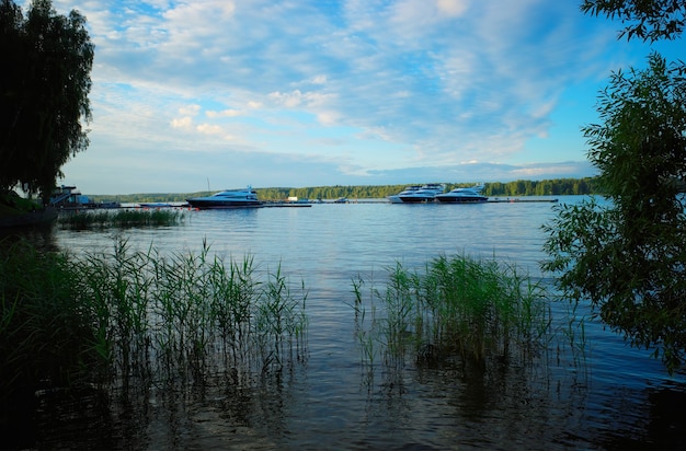 Yacht boats near backwater river bank background