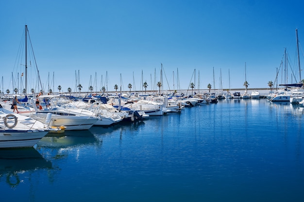 Yacht harbor in blue sunset light, luxury summer cruise, leisure time, active life, vacation and holidays concept Yachts and their reflection in the city's port.