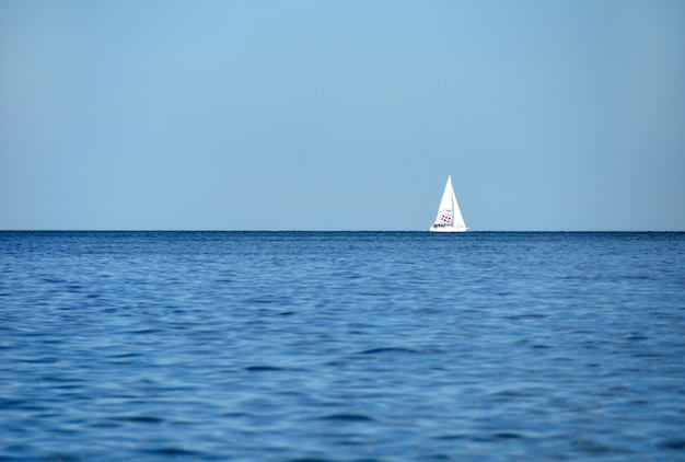 A yacht with tourists sails on the blue sea