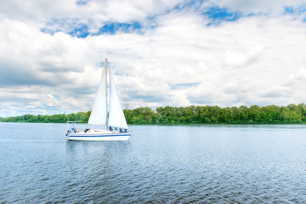 Yacht con vela bianca sull'acqua blu