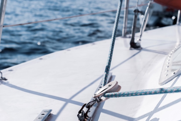 yachting fragment of the hull of a sailboat with rigging against the backdrop of water