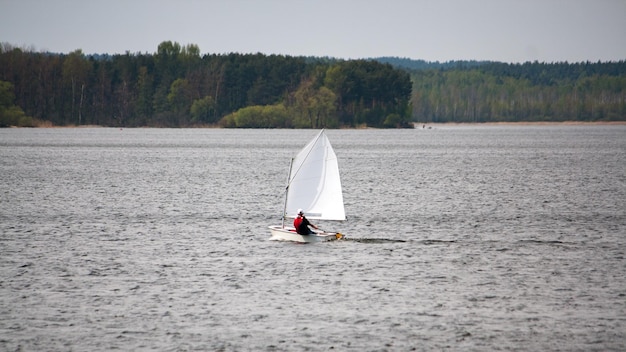 Управление небольшой яхтой с одним членом экипажа, мчащейся по волнам