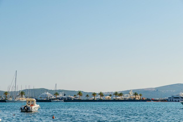 Yachts and boats in city bay mountains on background